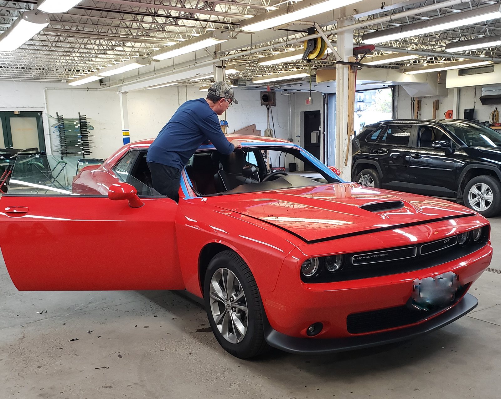 SGI technician installing a windshield on a Dodge Challenger