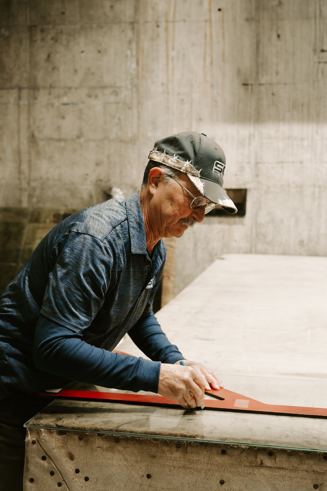 SGI technician cutting flat glass at the bench