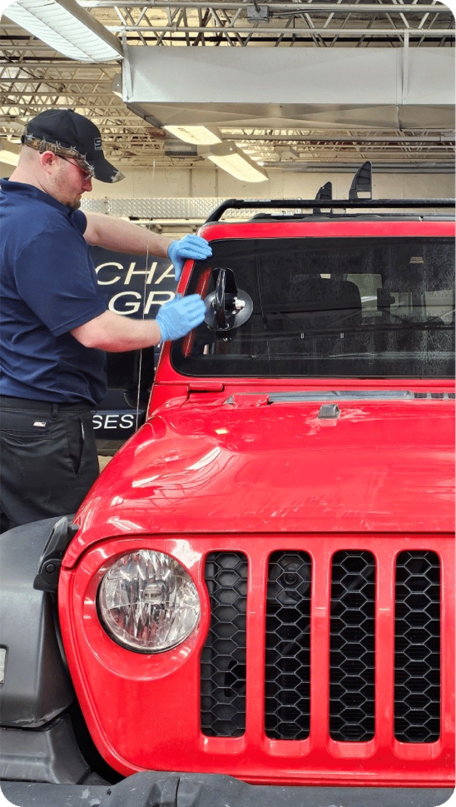 SGI Auto Glass technician installing a windshield on a red Jeep