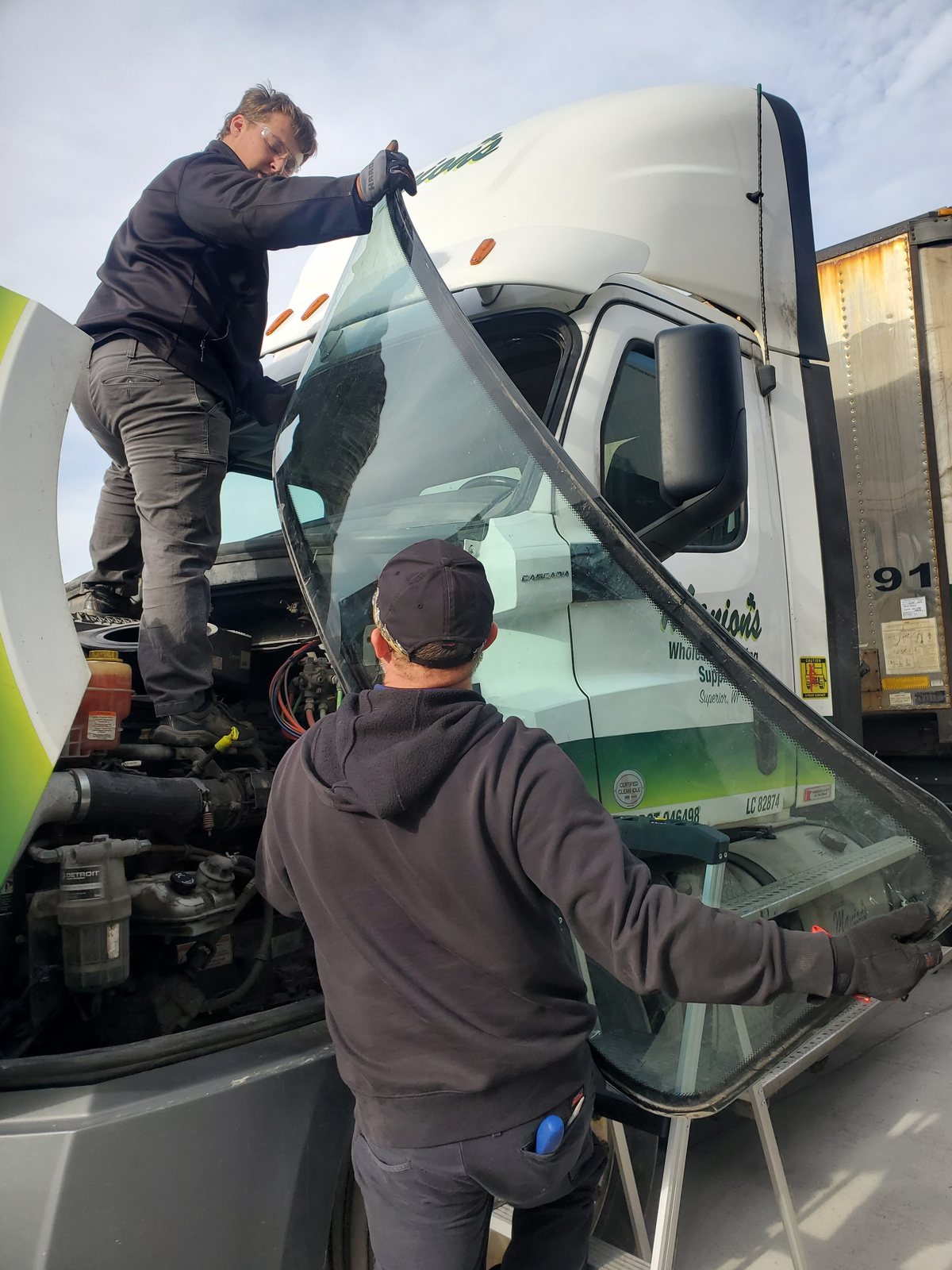 SGI technician setting a windshield on a semi tractor